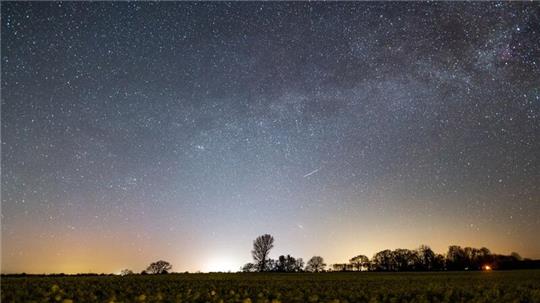 Der Sternenhimmel leuchtet über einem Rapsfeld in Schleswig-Holstein.