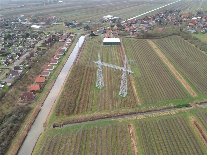 Der Tennet- Portalmast auf dem Obsthof Schuback soll abgebaut werden. Ein neuer klassischer Donaumast soll an der Ecke von Schöpfwerkskanal und Wettern vorne links errichtet werden. Foto: Tennet