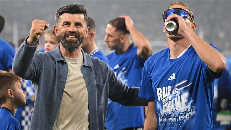 Der Trainer, die Spieler und ein Bier - die Party begann schon auf dem Rasen.