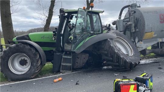 Der Traktor mit Anhänger wird bei dem Unfall stark beschädigt. Ein Hinterrad wird abgerissen.