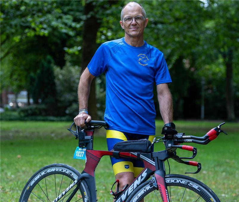 André Flömer steht hinter seinem Rennrad