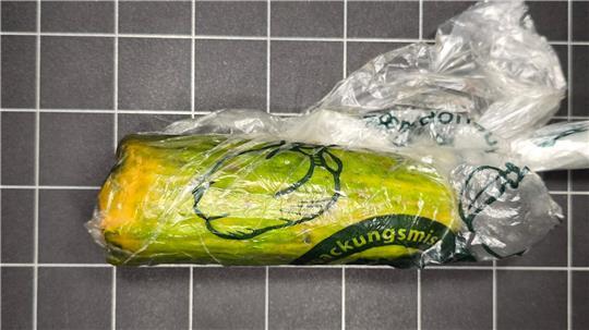 Der Vater der Frau nahm das Paket mit der Gurke an und bezahlte. 