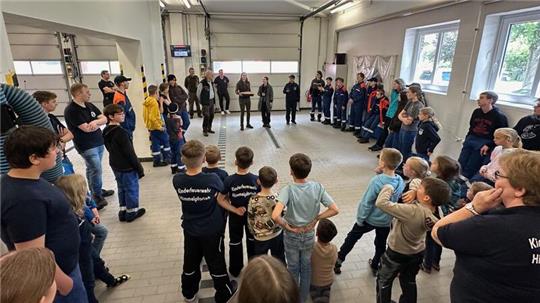 Der Versuch Miniwaldbrand: Mitglieder der Kinder- und Jugendfeuerwehr und Landesforst-Mitarbeiter im Gerätehaus in Himmelpforten.