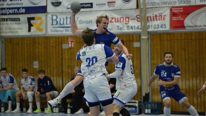 Der Handballer Niels Huckschlag beim Sprungwurf. Zwei Gegner attackieren ihn im der Luft.