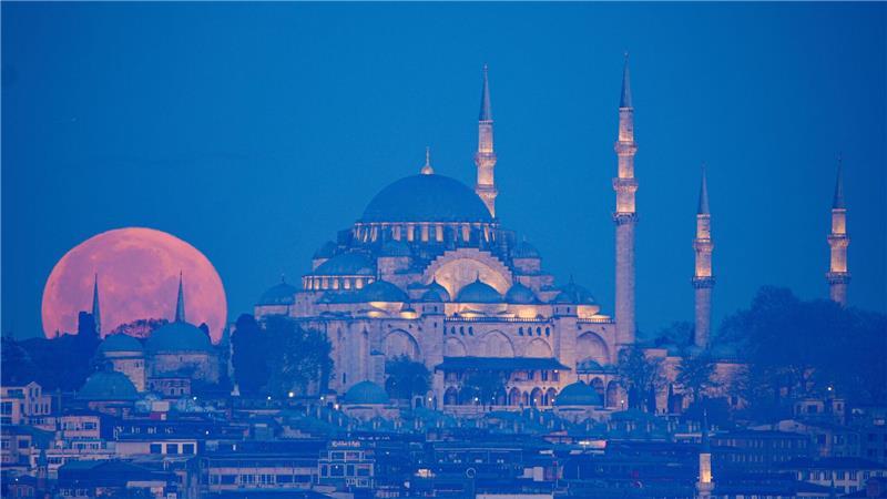 Der Vollmond geht hinter der Süleymaniye-Moschee unter.