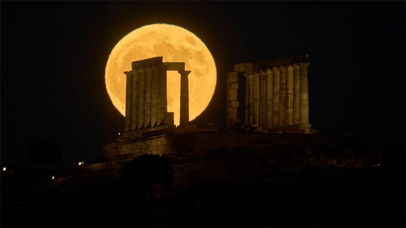 Der Vollmond steht hinter dem antiken Poseidon-Tempel am Kap Sounion in Griechenland.