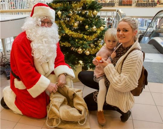 Der Weihnachtsmann bietet Mimi etwas aus seinem Jutesack an. Aber das soll lieber die Mama Sina Albers entgegennehmen. Foto: Dammer