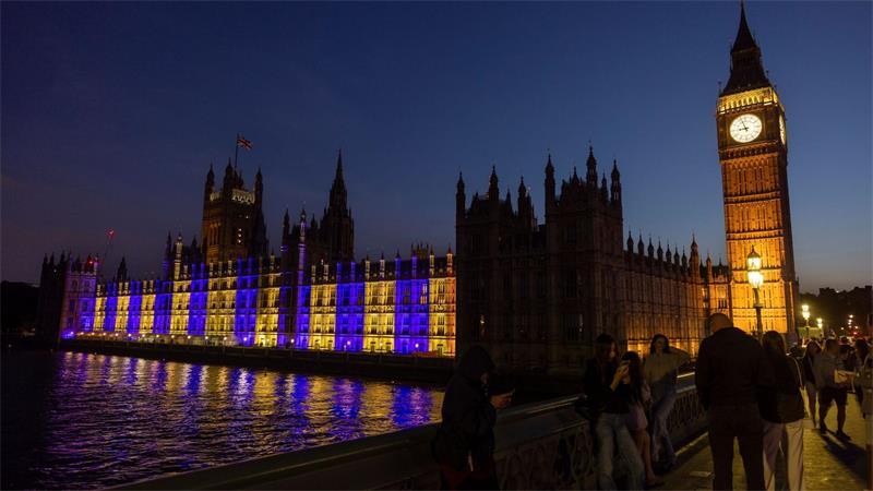 Der Westminster-Palast in London ist blau-gelb beleuchtet.