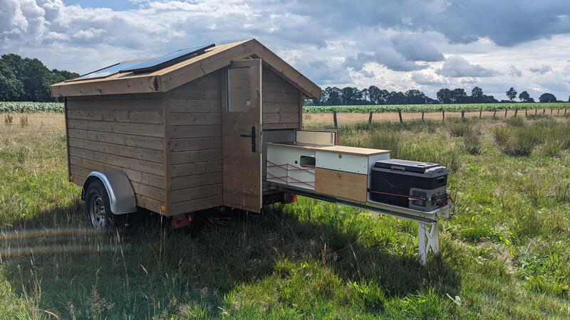 Der Wohnwagen aus Holz hat einen Küchenblock auf Schienen, der sich schnell herausziehen lässt.