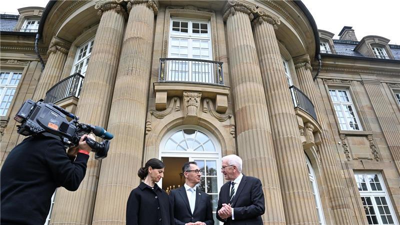 Özdemir ist neuer Ministerpräsident im Südwesten Der alte und der neue Hausherr: Winfried Kretschmann, Cem Özdemir und Özdemirs Ehefrau Flavia Zaka stehen vor der Villa Reitzenstein.