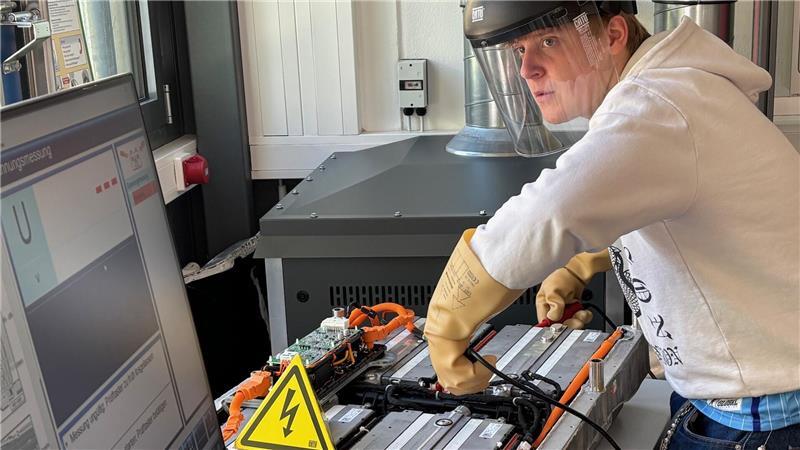 Der angehende Kfz-Mechatroniker Jakob Lieping misst im neuen Kompetenzzentrum für E-Mobilität an den Berufsbildenden Schulen Buxtehude die Spannung einer E-Auto-Batterie.
