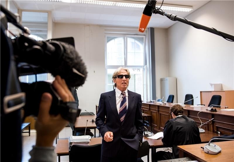 Der angeklagte mutmaßliche Serienbankräuber gibt im Landgericht vor Beginn der Verhandlung Interviews. Foto: Bockwoldt/dpa