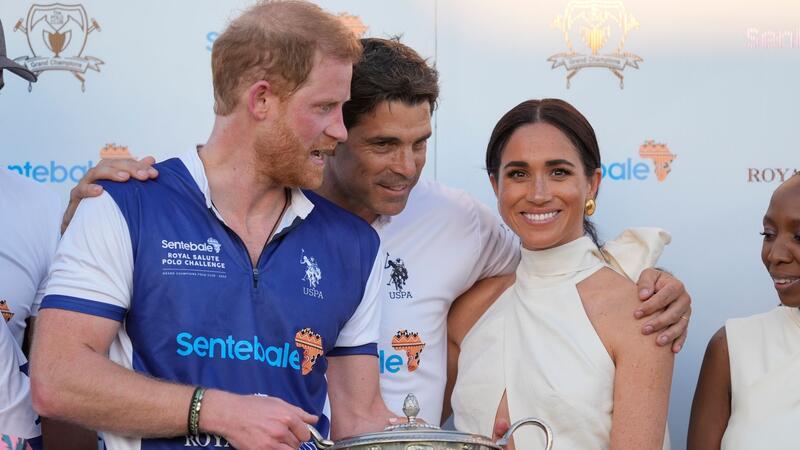 Der argentinische Profi-Polospieler Ignacio „Nacho“ Figueras (M) umarmt den britischen Prinzen Harry (l) und seine Frau Meghan Markle.