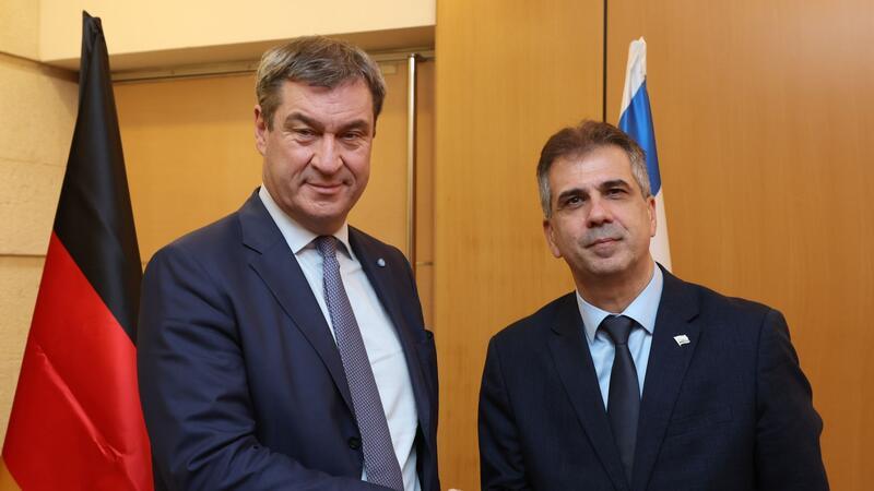 UN-Votum mahnt Israel zu Waffenruhe Der bayerische Ministerpräsident Markus Söder (l) wird von dem israelischen Außenminister Eli Cohen begrüßt.