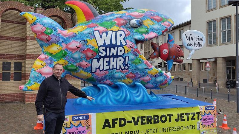 Bunter Fisch auf Berlinreise: Bündnis wirbt für AfD-Verbot Der bekannte Düsseldorfer Wagenbauer Jacques Tilly vor seinem Fisch. Er unterstützt damit die Forderung nach einem AfD-Verbot. (Handout-Bild)