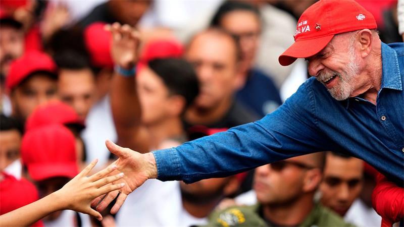 Der brasilianische Präsident Luiz Inácio Lula da Silva, der sich um eine Wiederwahl bewirbt, begrüßt einen Anhänger während seiner letzten Wahlkampfveranstaltung in São Paulo einen Tag vor der Stichwahl um das Präsidentenamt.