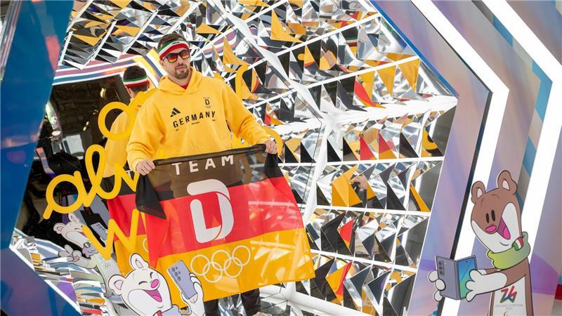 Der deutsche Eishockeyspieler Fabio Wagner steht während der Einkleidung für die Olympischen Winterspiele in Mailand für ein Video in einer verspiegelten Box.