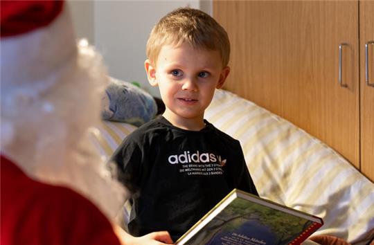 Der dreijährige Ben freut sich über den Besuch des Weihnachtsmanns in der Kinderklinik.