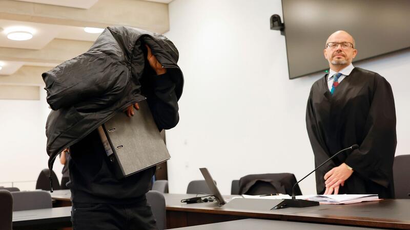 Vergewaltigungen in Asylheim: Haft für Ex-Security-Mann Der ehemalige Security-Mann bedeckt im Gerichtsaal seinen Kopf mit einer Jacke.