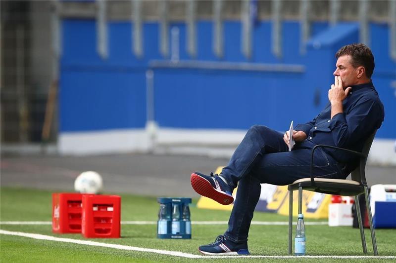 Der ehemalige Trainer Dieter Hecking sitzt bei einem Spiel des HSV am Spielfeldrand. Foto: Christian Charisius/dpa
