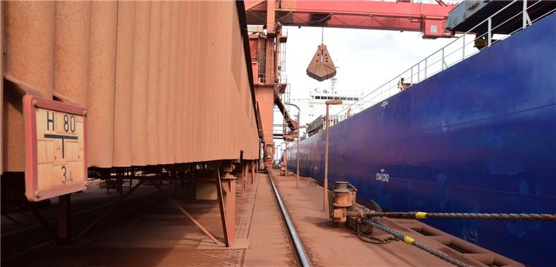 Der erste Schritt im AOS-Produktionsprozess: Vom Schiff im Bützflether Hafen wird Bauxit aus Westafrika verladen. Über Förderbänder geht der rotfarbene, geröllähnliche Rohstoff auf das Fabrikgelände.