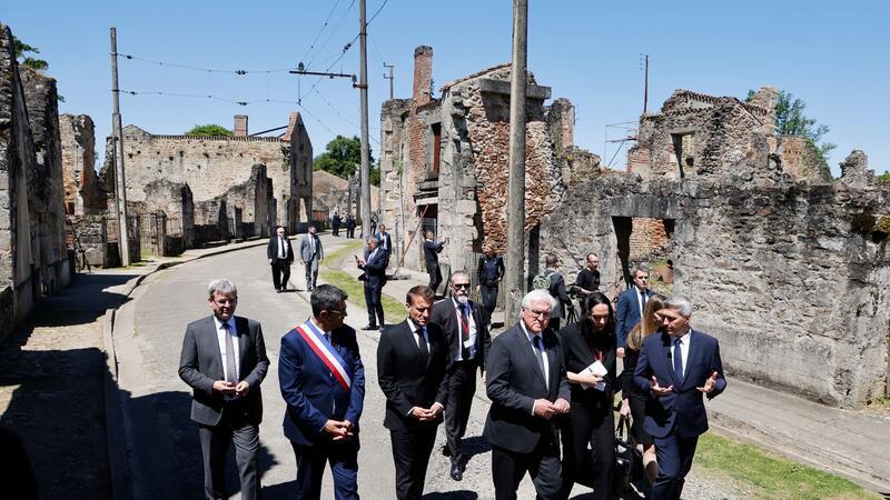 Versöhnungsgesten am Ort des SS-Massakers Der französische Präsident Emmanuel Macron und der deutsche Bundespräsident Frank-Walter Steinmeier gehen an Ruinen in Oradour-sur-Glane vorbei.
