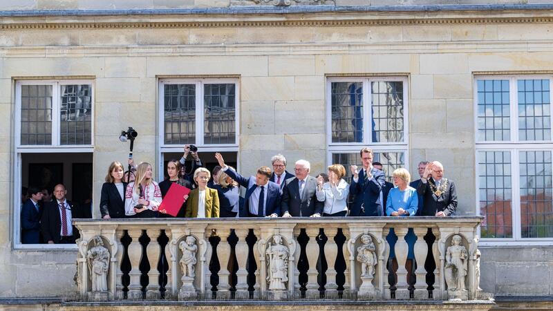 Der französische Präsident Emmanuel Macron winkt der Menge vom Balkon des Stadtweinhauses zu.