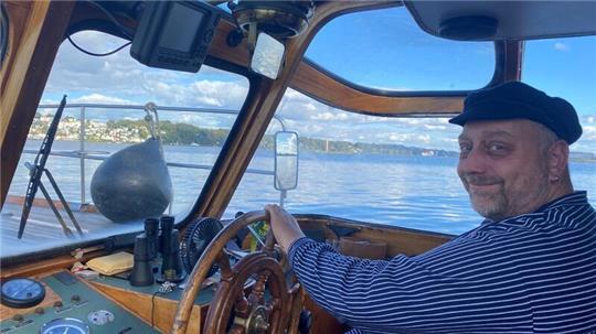 Andre Christoleit sitzt am Steuer seiner Barkasse, mit Blick auf Blankenese