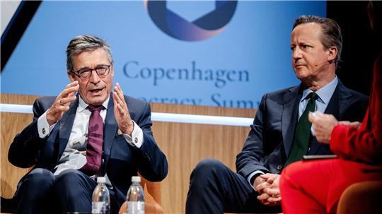Der frühere Nato-Generalsekretär Anders Fogh Rasmussen (l) wirbt für einen Zusammenschluss der demokratischen Mittelmächte. Hier redet er mit dem  ehemaligen britischen Premierminister James Cameron auf einem Demokratie-Gipfel in Kopenhagen. (Archivbild)