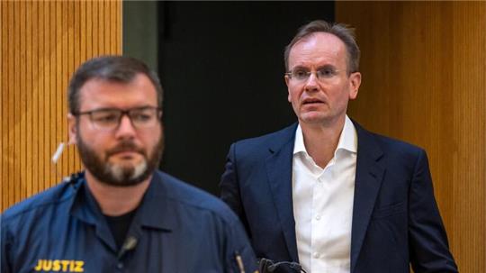 Der früheren Wirecard-Vorstandschef Markus Braun (r) wird von einem Justizbeamten in den Gerichtssaal begleitet (Archivbild).