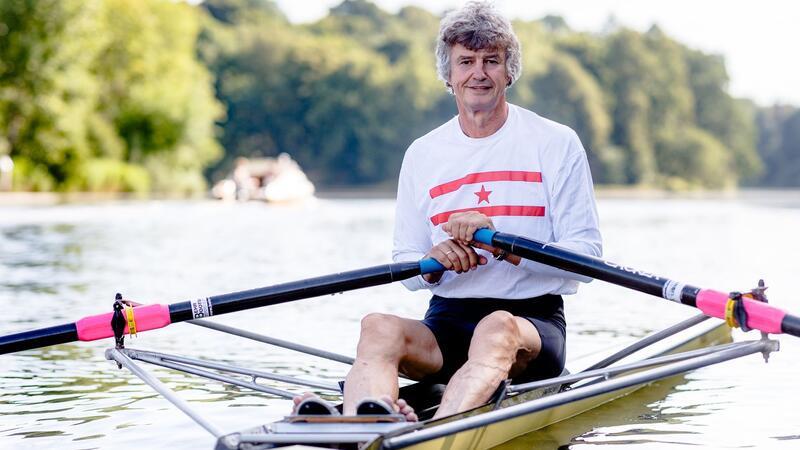 Der fünffache Ruderweltmeister Peter-Michael Kolbe sitzt auf der Trave in einem Ruder-Einer.