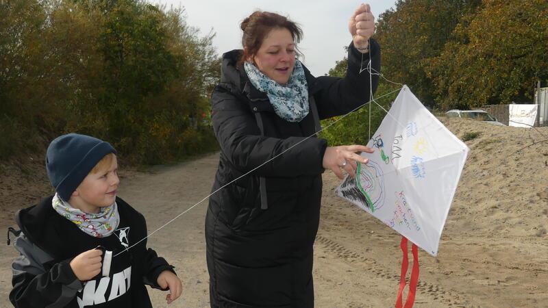 Drachenfest: Fahrstuhlwind zwingt Adler auf Krautsand zur Landung Der fünfjährige Tom aus der Wingst lässt seinen selbst bemalten Drachen fliegen. Mutter Melanie Adrian leistet nur am Anfang ein bisschen Starthilfe - den Rest macht der Wind.