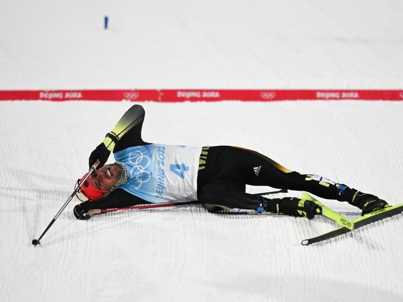 Der fünftplatzierte Johannes Rydzek liegt nach dem Rennen entkräftet am Boden. Foto: Hendrik Schmidt/dpa