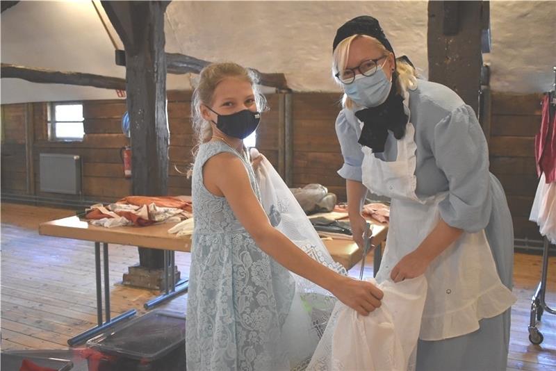 Ahlerstedter Schüler auf Entdeckungsreise im Agathenburger Schloss Der für seine Jazzkonzerte bekannte Pferdestall ist in der Schlosswoche zur Kleiderkammer umfunktioniert. Lehrerin Jessica Kirst hilft Femke beim Zuschneiden von Stoff für eine Schleppe. Fotos: Weselmann