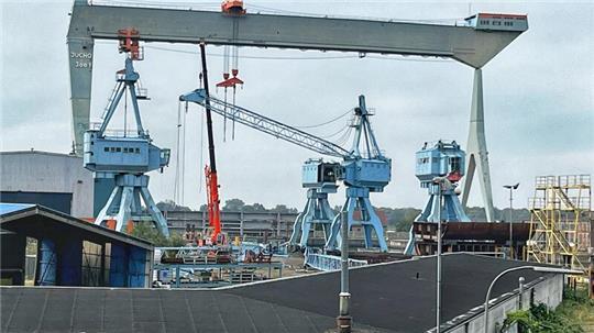 Der große Jucho-Portalkran wird bald allein stehen: Die vier kleinen Liebherr-Kräne sind verkauft und reisen nach Vietnam.