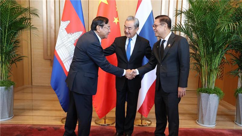 Der kambodschanische Außenminister Prak Sokhonn (l) schüttelt die Hand seines thailändischen Amtskollegen Sihasak Phuangketkeow (r) vor dem chinesischen Amtskollegen Wang Yi.