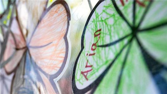 Gebastelte vierblättrige Kleeblätter mit der Aufschrift «Arian» hängen an einem Zaun im Wohnort von Arians Familie.