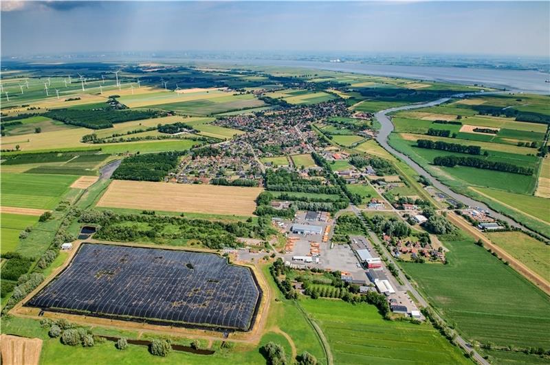 Der mit schwarzer Folie eingedeckte Bereich ist die Deponie Wischhafen II. Oberhalb auf der bewachsenen Fläche befindet sich die stillgelegte Deponie Wischhafen I. Das Karl-Meyer-Firmengelände liegt rechts von der Deponie. Der Ort Wischhafe