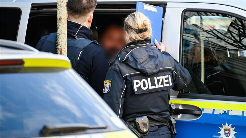 Täter hält Bankmitarbeiterin stundenlang fest - Motiv unklar Der mutmaßliche Täter wurde nach der Festnahme in ein Polizeiauto gebracht.