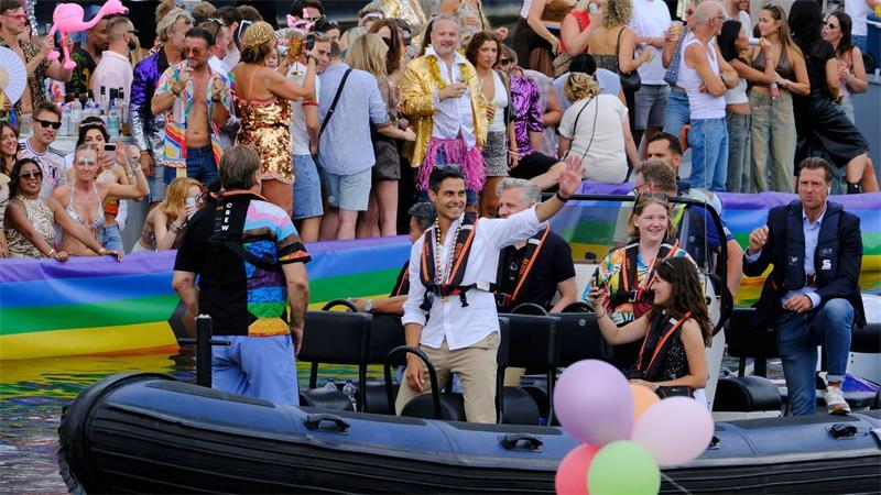 Der niederländische Ministerpräsident Rob Jetten steht auf einem Boot und winkt während der Canal Parade in Amsterdam.