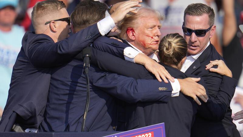 Der republikanische Präsidentschaftsbewerberund frühere US-Präsident Donald Trump wird von Agenten des US-Geheimdienstes Secret Service umringt, als ihm bei einer Wahlkampfveranstaltung von der Bühne geholfen wird. Trump wurde während des Wahlkampfes attackiert.