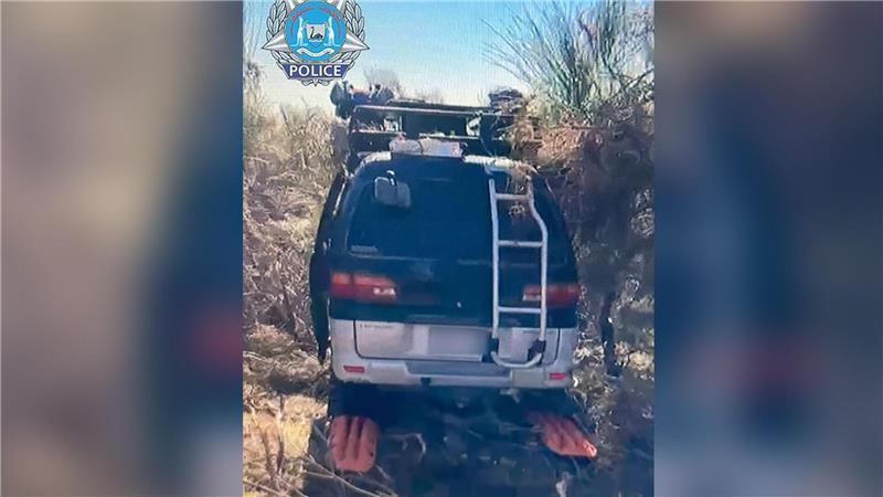 Der schwarze Mitsubishi-Van stand in dichtem Buschland mitten im Outback.
