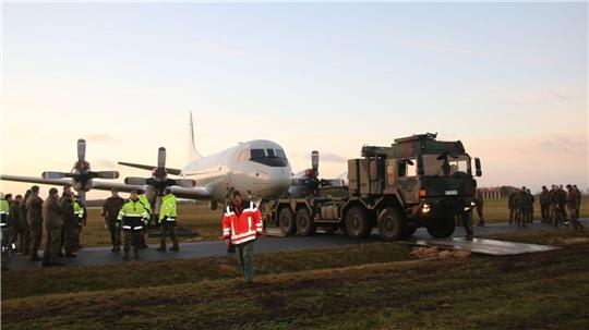 Der schwere Militär-Lkw zieht die ausgemusterte "P-3 Orion" in Richtung des Geländes der Sportfluggruppe. Soldaten des Marinefliegergeschwaders begleiten jeden Meter der heiklen Überführung zum Aeronauticum. 
