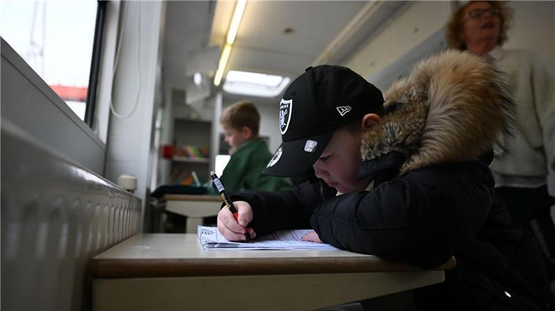 Lernen mitten auf dem Rummel: Hamburger Domschule wieder in Betrieb Der siebenjährige Milo ist noch Vorschüler, kommt aber trotzdem schon in den Schulwagen - auch um hier andere Kinder kennenzulernen.