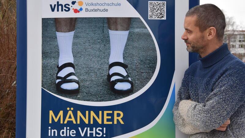 Der stellvertretende VHS-Leiter Tobias Rothenberg blickt auf das Titelfoto des aktuellen Programms. Er wird am kommenden Donnerstag mit Besuchern über Diskriminierung und Männlichkeit diskutieren.