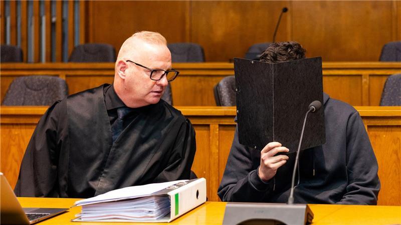 Der wegen Mordes angeklagte junge Mann sitzt neben seinem Verteidiger Michael Rehberger im Landgericht Saarbrücken.