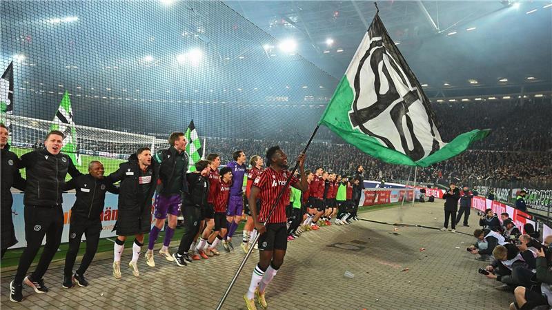 Derby-Jubel nach dem 1:0 gegen Braunschweig. Hannovers Mustapha Bundu schwenkt vor der Fankurve die 96-Fahne.