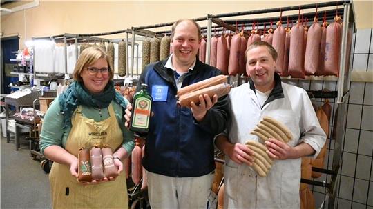 Désirée Quast, Jan-Eric Quast und ihr Mitarbeiter Sven Cehmke (von links) präsentieren die Bandbreite der Produkte: In der Mitte zeigt der Fleischermeister die Altländer Jägermeister-Mettwurst. Foto: Vasel