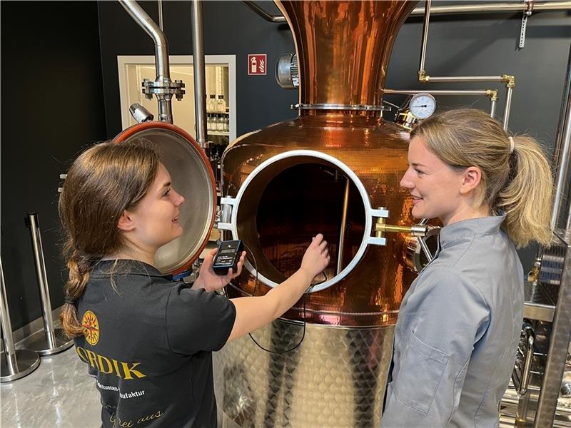 Destillateurin Lea Weßel und Konditorin Annelen Dietz haben gemeinsam einen Franzbrötchenlikör entwickelt (von links). Hier messen sie die Temperatur der Maische in der Brennanlage bei Nordik in Horneburg. Foto: Vasel