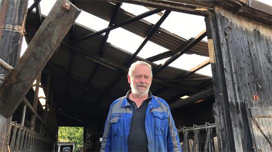 Detlef Ahlf vor dem teilweise abgedeckten Stall.